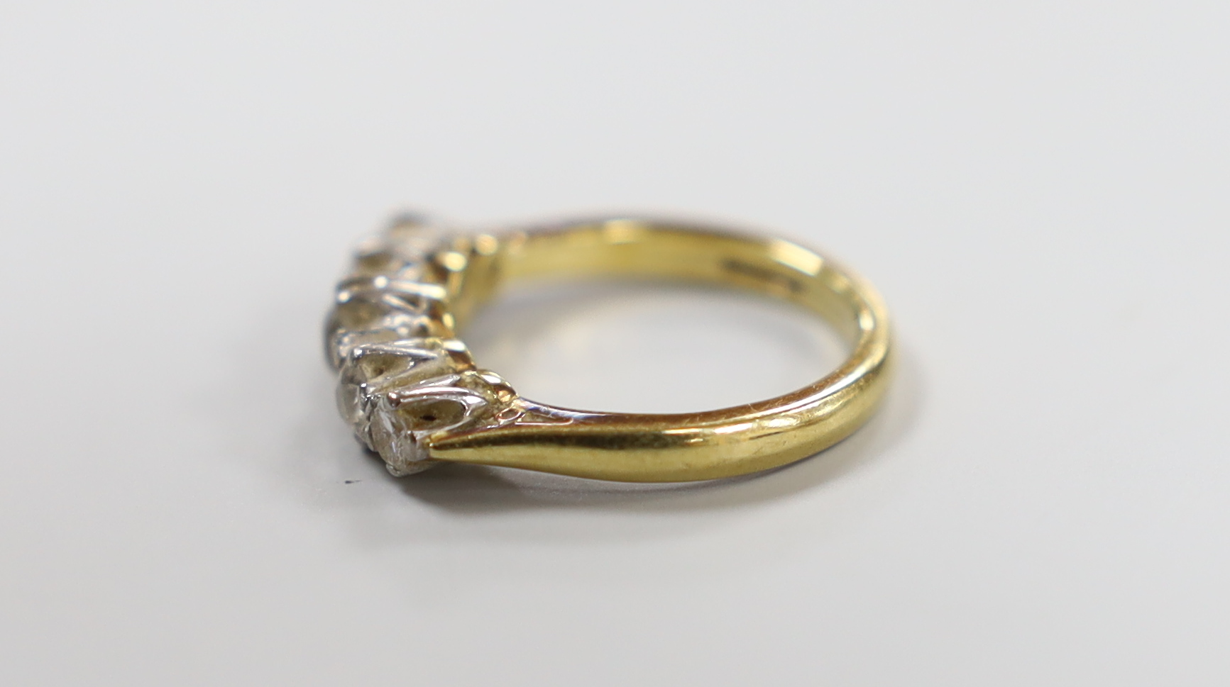 A modern 18ct gold and graduated five stone diamond set half hoop ring, size J, gross weight 3.9 grams.